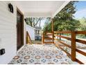 Covered front porch with decorative tile flooring, wood railing, and views of the lush surroundings at 2007 Glenwood Se Ave, Atlanta, GA 30316