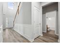 Bright entryway featuring hardwood floors, staircase, and view of a bathroom at 210 Millpond Pkwy, Villa Rica, GA 30180