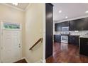 Foyer with a view of a kitchen that offers stainless steel appliances and dark wood flooring at 4934 Wyeth Way, Johns Creek, GA 30022
