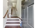 Inviting entryway with wood stairs and railing leading to the upper level and hardwood flooring at 4934 Wyeth Way, Johns Creek, GA 30022