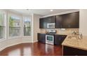 Modern kitchen featuring dark cabinets, granite countertops, and stainless steel appliances at 4934 Wyeth Way, Johns Creek, GA 30022