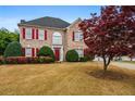 Charming brick home with red shutters and a well-manicured front yard at 5578 Hedge Brooke Dr, Acworth, GA 30101