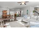 Open-concept living area with a large sectional, hardwood floors, and views of dining and kitchen areas at 5135 Arnold St, Covington, GA 30014