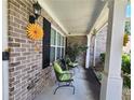 The home's covered front porch has brick accents, green cushioned chairs, and decorative sunflower accents at 828 Cooper Lakes Ct, Grayson, GA 30017