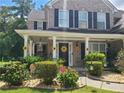 Beautiful two-story brick home with black shutters, a covered front porch, and well-maintained landscaping at 828 Cooper Lakes Ct, Grayson, GA 30017