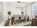 Dining room featuring modern lighting, a dining table with seating for six, and natural light from the window at 139 Rushing View Gln, Dallas, GA 30157