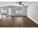 Spacious living room with ceiling fan, hardwood floors, large windows, and backyard views at 280 Mcgiboney Ln, Covington, GA 30016