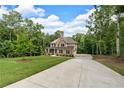 Attractive two-story home featuring a brick facade, a covered porch, and a long driveway on a sprawling lawn at 7580 Sunridge Ln, Douglasville, GA 30135