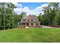 Charming two-story brick home with a covered front porch, large windows, and a lush green lawn at 7580 Sunridge Ln, Douglasville, GA 30135