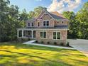Charming brick house with a covered porch, stone accents, and a neatly landscaped lawn at 7580 Sunridge Ln, Douglasville, GA 30135