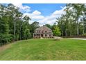 Spacious two-story brick home nestled on a large lot surrounded by mature trees and lush green grass at 7580 Sunridge Ln, Douglasville, GA 30135