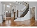 Grand foyer with hardwood floors, staircase with iron railing, and double front doors at 5950 Thoroughbred Way, Suwanee, GA 30024
