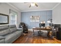 Cozy home office with hardwood floors, wainscoting, a large desk, and a comfortable leather sofa at 5950 Thoroughbred Way, Suwanee, GA 30024