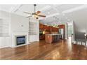 Open-concept living room with hardwood flooring, a fireplace, and an open kitchen at 900 River Vista Dr, Atlanta, GA 30339