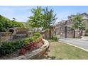 Gated entrance to Townsend at Lenox Park with stone wall and manicured landscaping at 1384 Doublegate Dr, Brookhaven, GA 30319