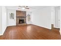 Living room with hardwood floors, stone fireplace, ceiling fan, and bright white walls at 2199 Summertown Dr, Norcross, GA 30071