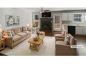 Staged living room featuring a fireplace, neutral furniture, hardwood floors, and lots of natural light at 46 Norman Rd, Covington, GA 30014