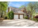 Side view of brick home featuring an attached two-car garage and long driveway at 5145 Southlake Dr, Alpharetta, GA 30005