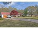 Ranch-style house with a red roof, attached garage, covered porch, and a spacious front yard with mature tree at 6690 Pine Ridge Cir, Cumming, GA 30041