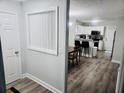 Hallway leading to kitchen with wood floors, neutral paint, and modern light fixtures at 5980 Sherwood Trce, Lithonia, GA 30038