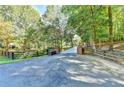 Long driveway lined with trees and a wooden fence leading up to the home at 2962 Norman Cir, Duluth, GA 30096