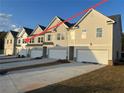 Exterior view of a row of new townhomes, each with its own two car garage and driveway at 6324 Rosetta Drive, Lot 2, South Fulton, GA 30331