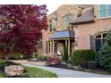Close up of a stately brick home's entrance with a stone facade, a walkway and a mature tree at 3053 Cambridge Hill Dr, Dacula, GA 30019