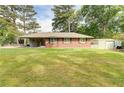 Single-story brick home with black shutters and a large grassy front yard and a detached garage at 3221 Colquitt Dr, Atlanta, GA 30340