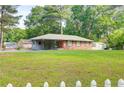 A single-story home with a spacious front yard, shed, and a charming white picket fence at 3221 Colquitt Dr, Atlanta, GA 30340