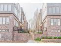 Close-up of townhome exteriors with brick facade, stairs, and green landscaping at 379 Pratt Se Dr # 408, Atlanta, GA 30315