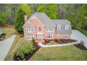 Attractive brick home featuring a well manicured lawn, flowering shrubs, and a welcoming walkway at 1343 Riverview Run Ln, Suwanee, GA 30024