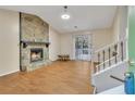 Cozy living room features a stone fireplace, wood floors, and a sliding glass door to the outdoor deck at 1077 Mainstreet Valley Dr, Stone Mountain, GA 30088
