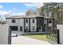 Beautiful new construction home featuring white brick, black trim, and a spacious two-car garage at 1688 Mineral Springs Rd, Hoschton, GA 30548