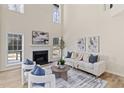 Bright living room with fireplace, large windows, light wood floors, and soaring ceilings at 3286 Sir Henry St, Atlanta, GA 30344