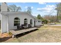 Side view of a white brick home featuring arched windows and a wooden deck at 5906 Rosie Se Ln, Mableton, GA 30126