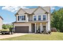 Charming two-story home features a well-manicured lawn, attached garage, and inviting front porch perfect for relaxing at 103 Cottage Way, Euharlee, GA 30145