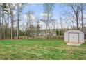 Lush backyard with mature trees and a storage shed, offering privacy and functionality at 121 Tricias Way, Temple, GA 30179