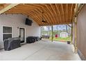 Inviting covered patio with a ceiling fan, outdoor television, and grill; perfect for outdoor living at 121 Tricias Way, Temple, GA 30179