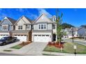 Charming townhome featuring a two-car garage, manicured lawn, and modern design at 2220 Lanier Harbor Pt, Buford, GA 30518