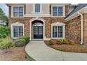 Close-up of the home's front door, featuring brick facade and manicured landscaping at 2723 Ivy Bluff Ct, Buford, GA 30519