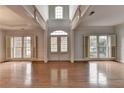 Open living room with hardwood floors, large windows, and high ceilings at 2723 Ivy Bluff Ct, Buford, GA 30519