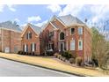 Stately brick home showcasing mature landscaping, a symmetrical facade, and ample natural light streaming through large windows at 4020 Balleycastle Ln, Duluth, GA 30097