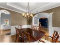 Dining room featuring hardwood floors, a coffered ceiling, and decorative chandelier at 5950 Bridge Stone Ct, Cumming, GA 30028