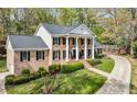 Well-manicured lawn and driveway enhance this beautiful brick home with striking black shutters and inviting front porch at 6124 Kings Mountain Ct, Stone Mountain, GA 30087