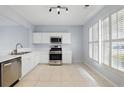 Bright kitchen featuring white cabinets, stainless steel appliances, and tile flooring at 10900 Wittenridge Dr # D5, Alpharetta, GA 30022