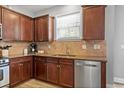 Close up of kitchen featuring granite countertops, stainless steel dishwasher, and tile backsplash at 3806 Carriage House Dr, Cumming, GA 30040