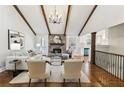Cozy living area with a stone fireplace, hardwood floors, and exposed beam vaulted ceiling at 645 Trailmore Pl, Roswell, GA 30076