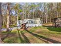 Cozy home nestled among tall trees on a verdant lawn with a partial view of the drive at 2466 Monroe Jersey Rd, Covington, GA 30014