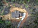 Aerial view showing a home's roofline, driveway, and the surrounding wooded lot at 313 Morgan Rd, Temple, GA 30179