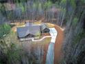 An aerial view displays this home nestled in a wooded area with a decorative driveway and inviting front porch at 313 Morgan Rd, Temple, GA 30179